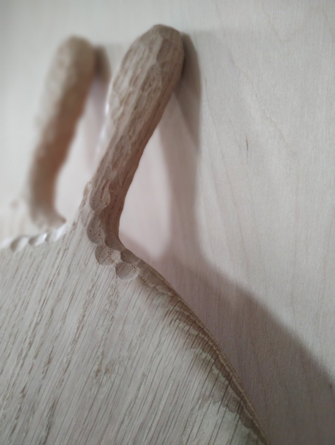 Wooden pizza board corner view with carved handle detail