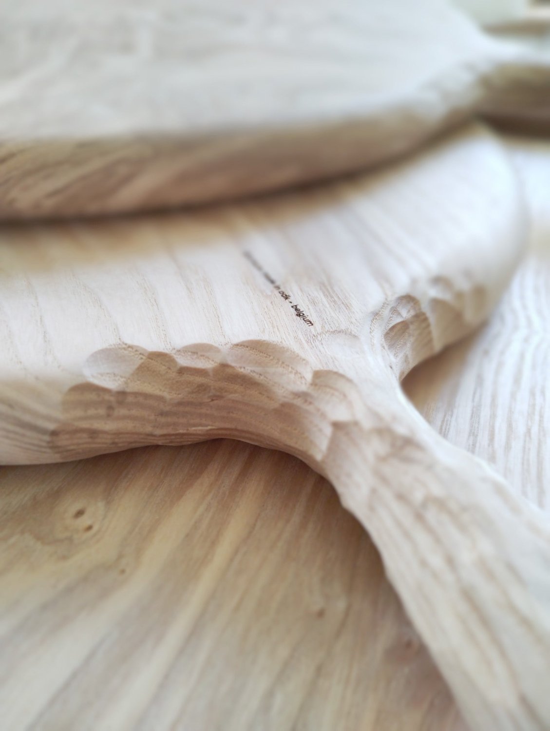 Wooden pizza board with carved handle joint and visible wood grain