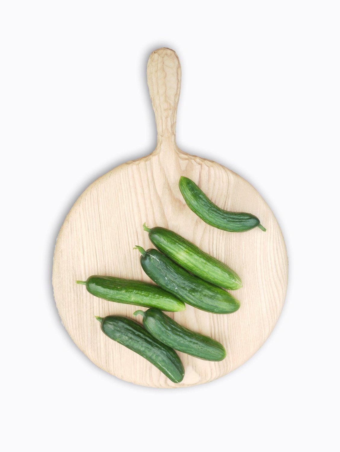 Light wooden round pizza board with handle and green chili peppers on it