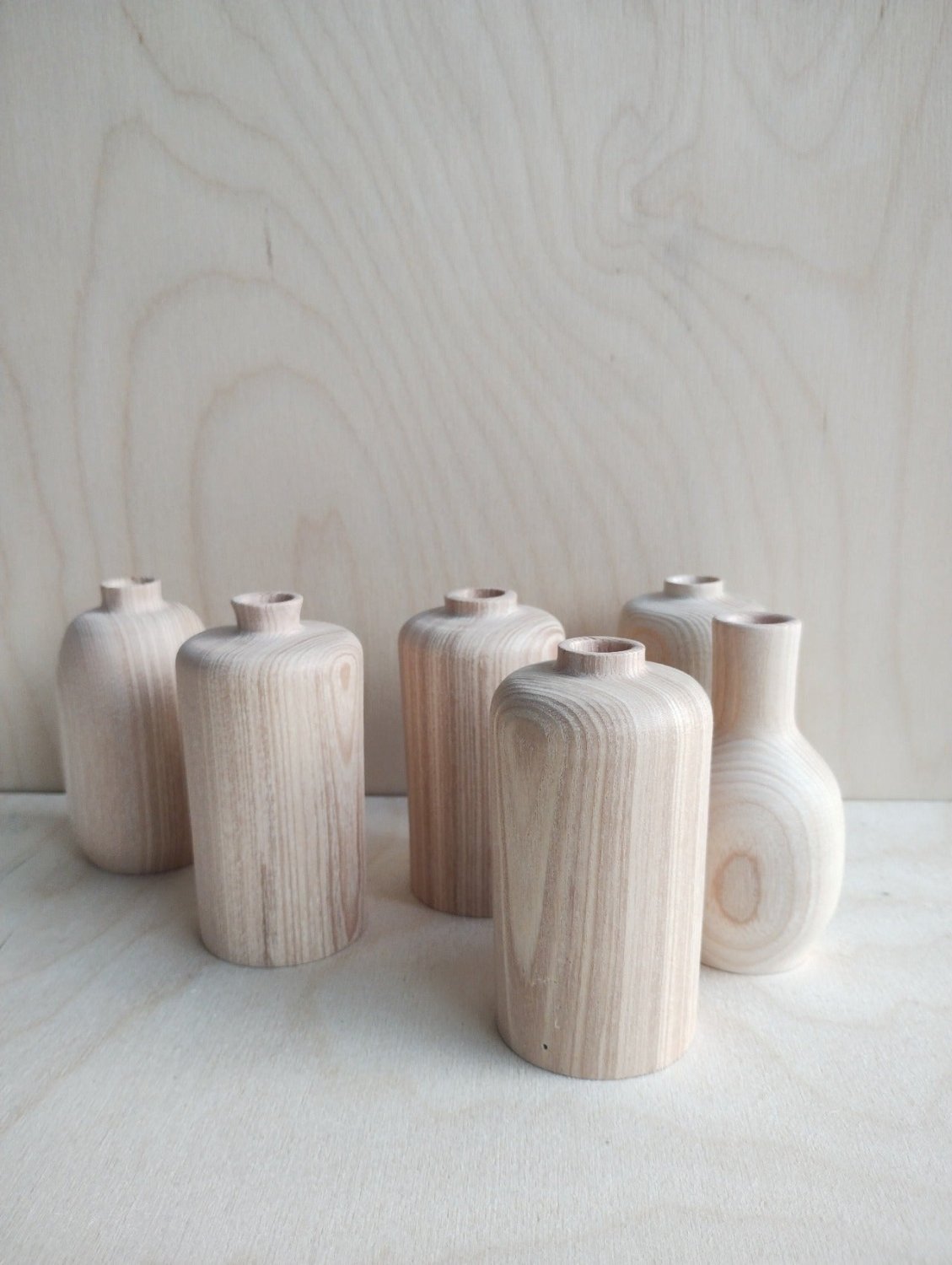 Set of small vases in light wood and white tones, upright with narrow openings