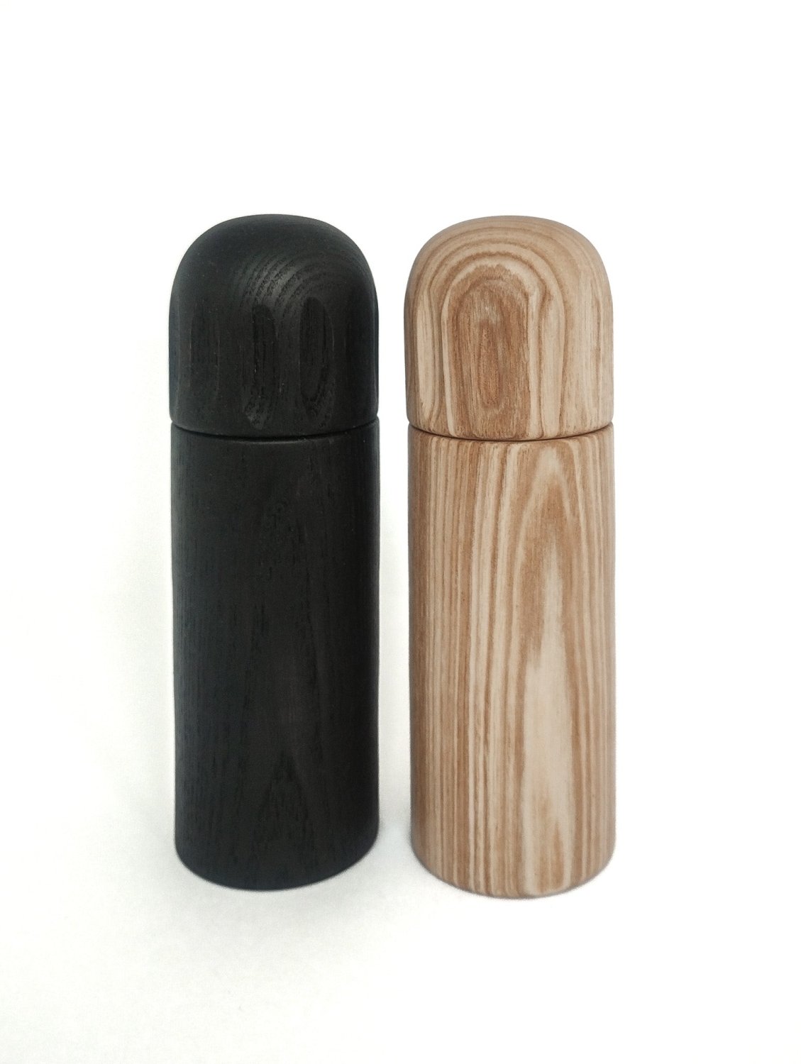 Pair of pepper grinders: one dark wood, one light wood, both with rounded tops