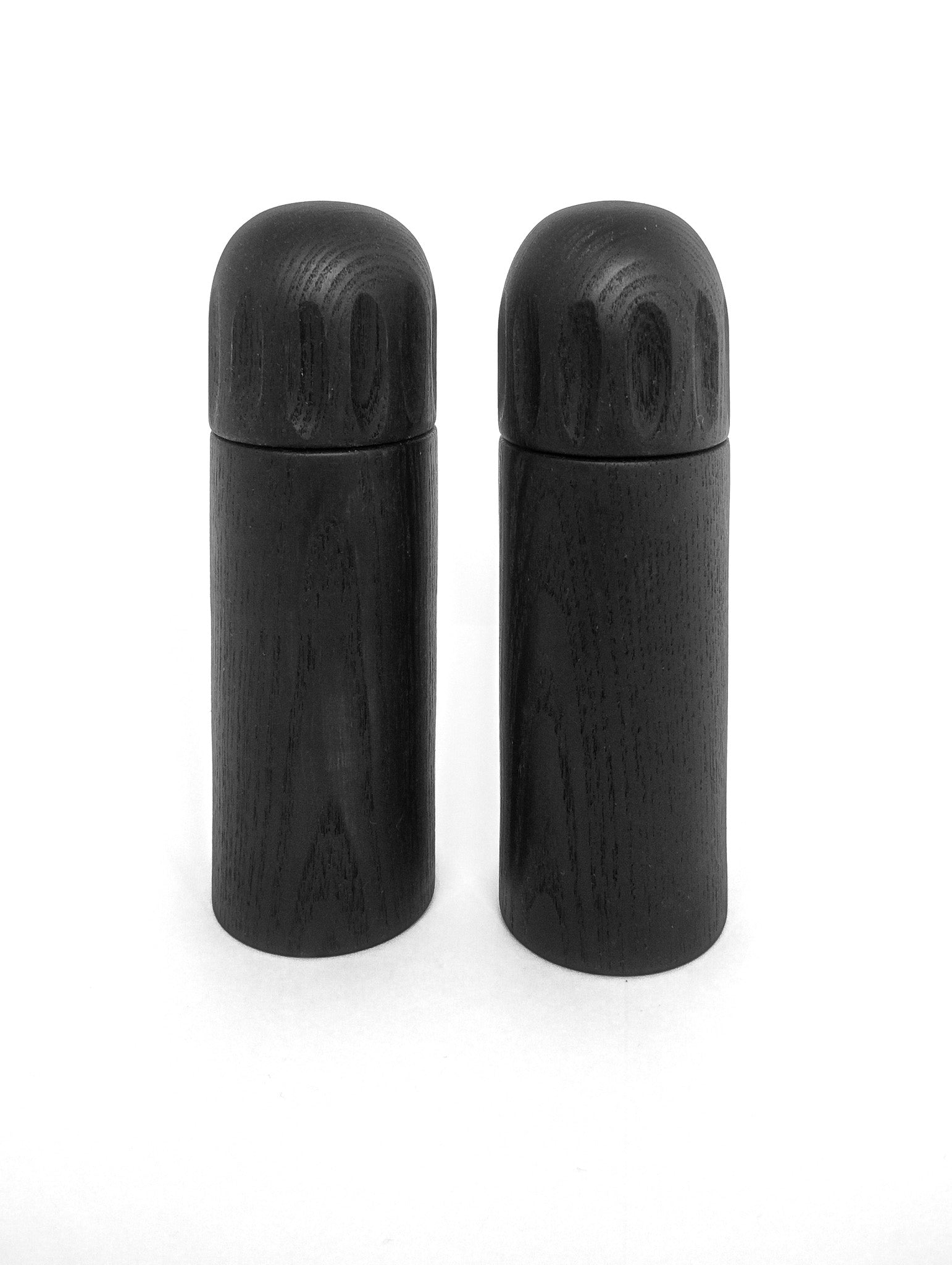Two dark wood pepper grinders with rounded tops and smooth cylindrical bodies