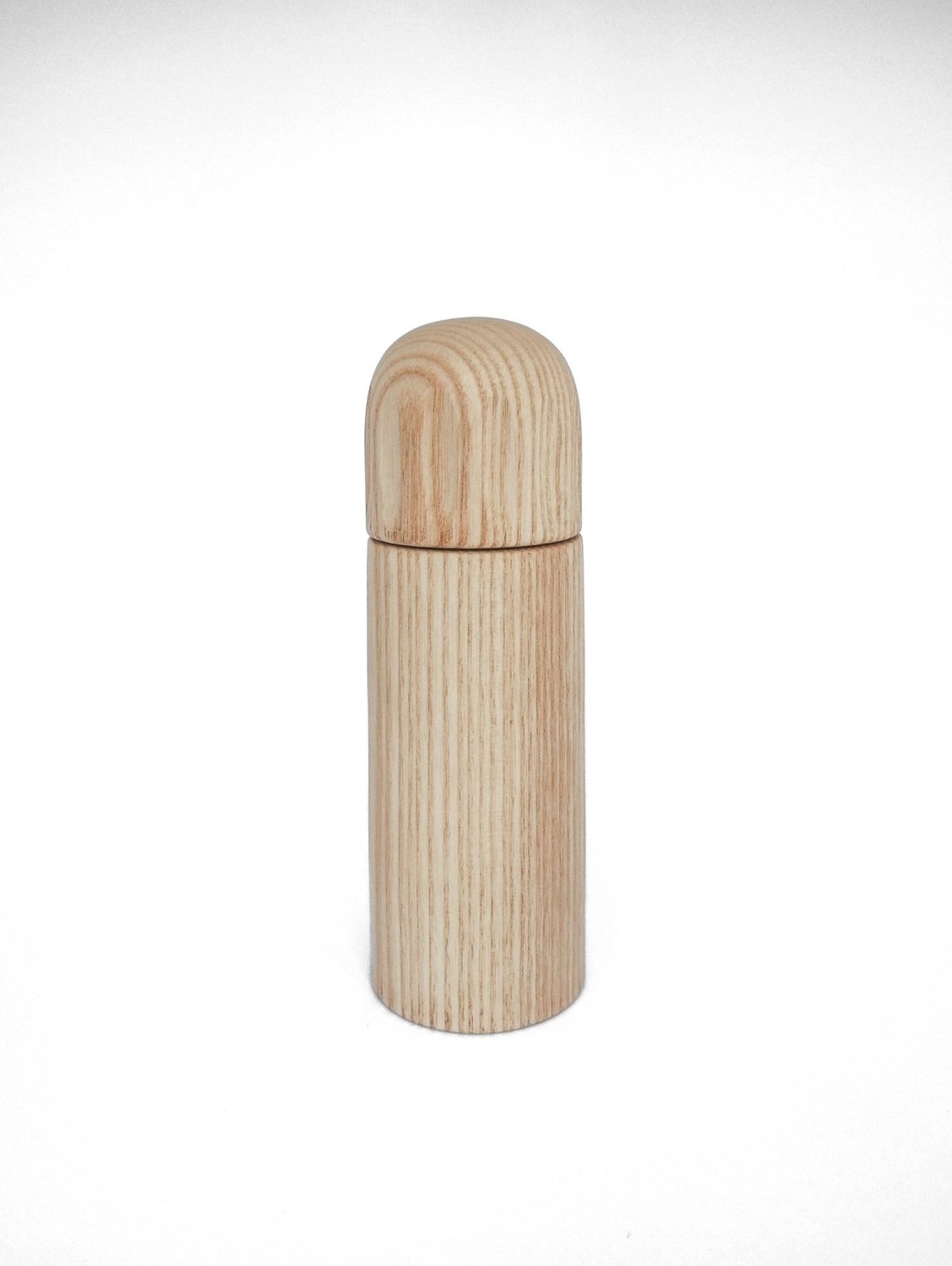 Light wood pepper grinder with rounded top and smooth cylindrical body