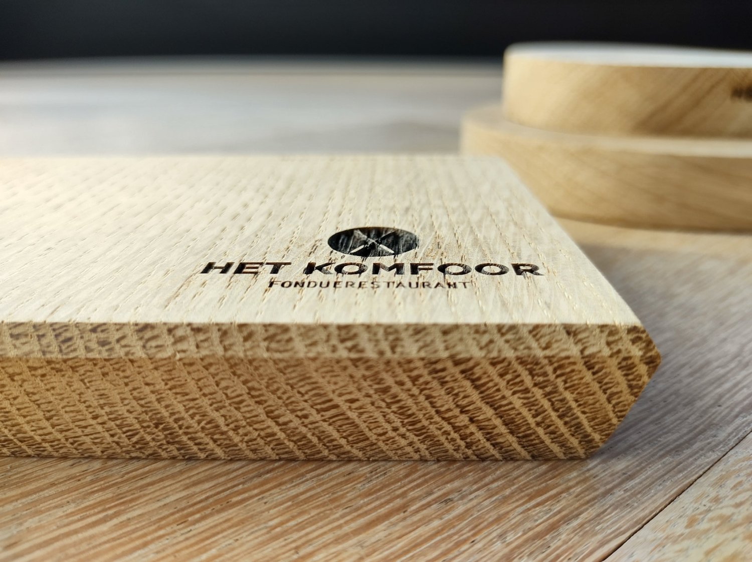 Engraved wooden board with restaurant logo text