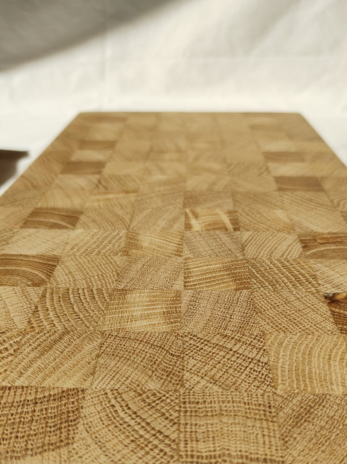 Wooden cutting board top with patchwork wood-grain pattern and fine woven texture