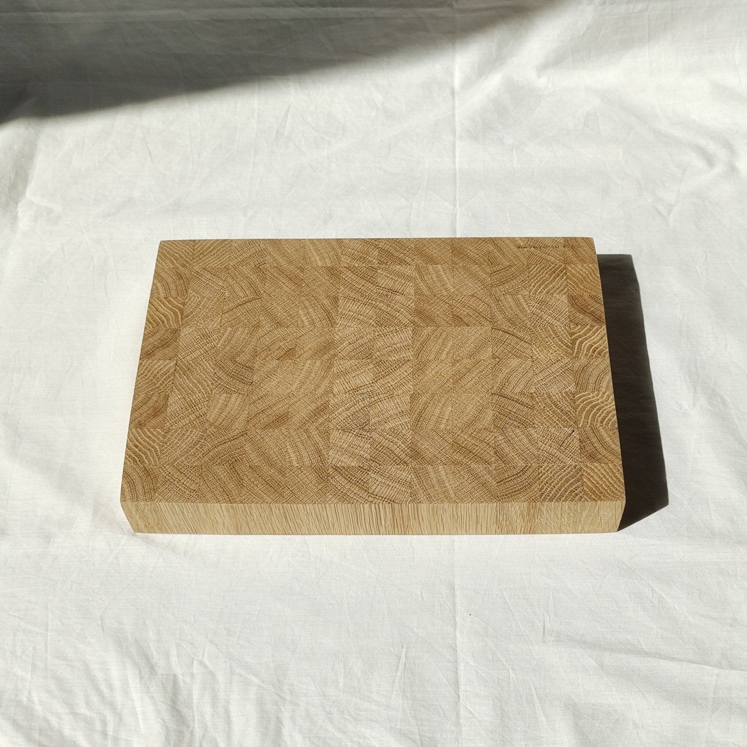 Wooden cutting board with rounded corners and patchwork wood-grain pattern