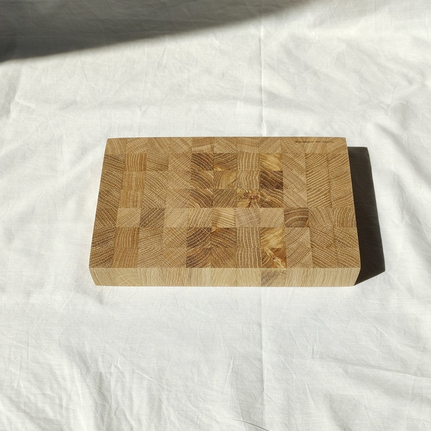 Wooden cutting board with patchwork wood blocks and rounded corner shape