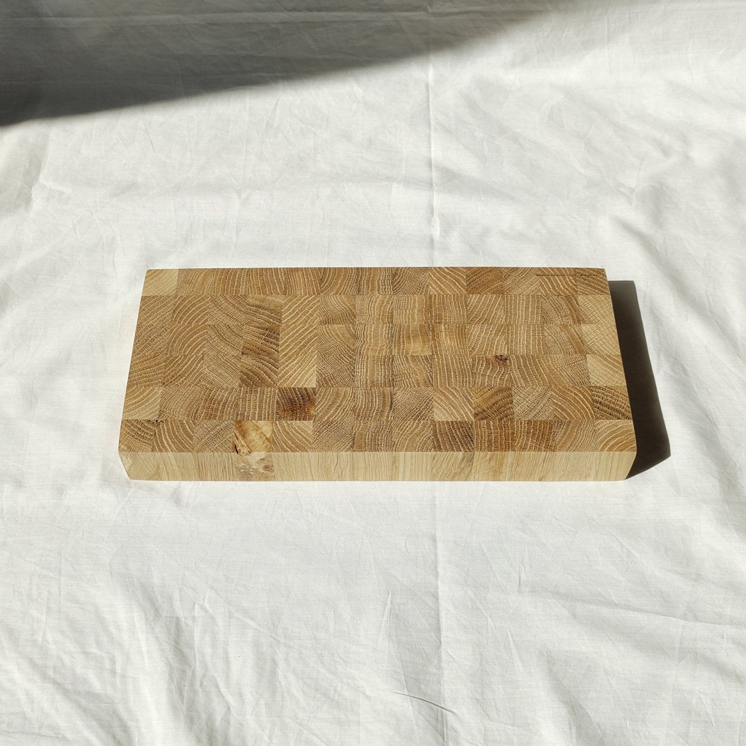 Wooden cutting board angled view showing patchwork top and beveled edges