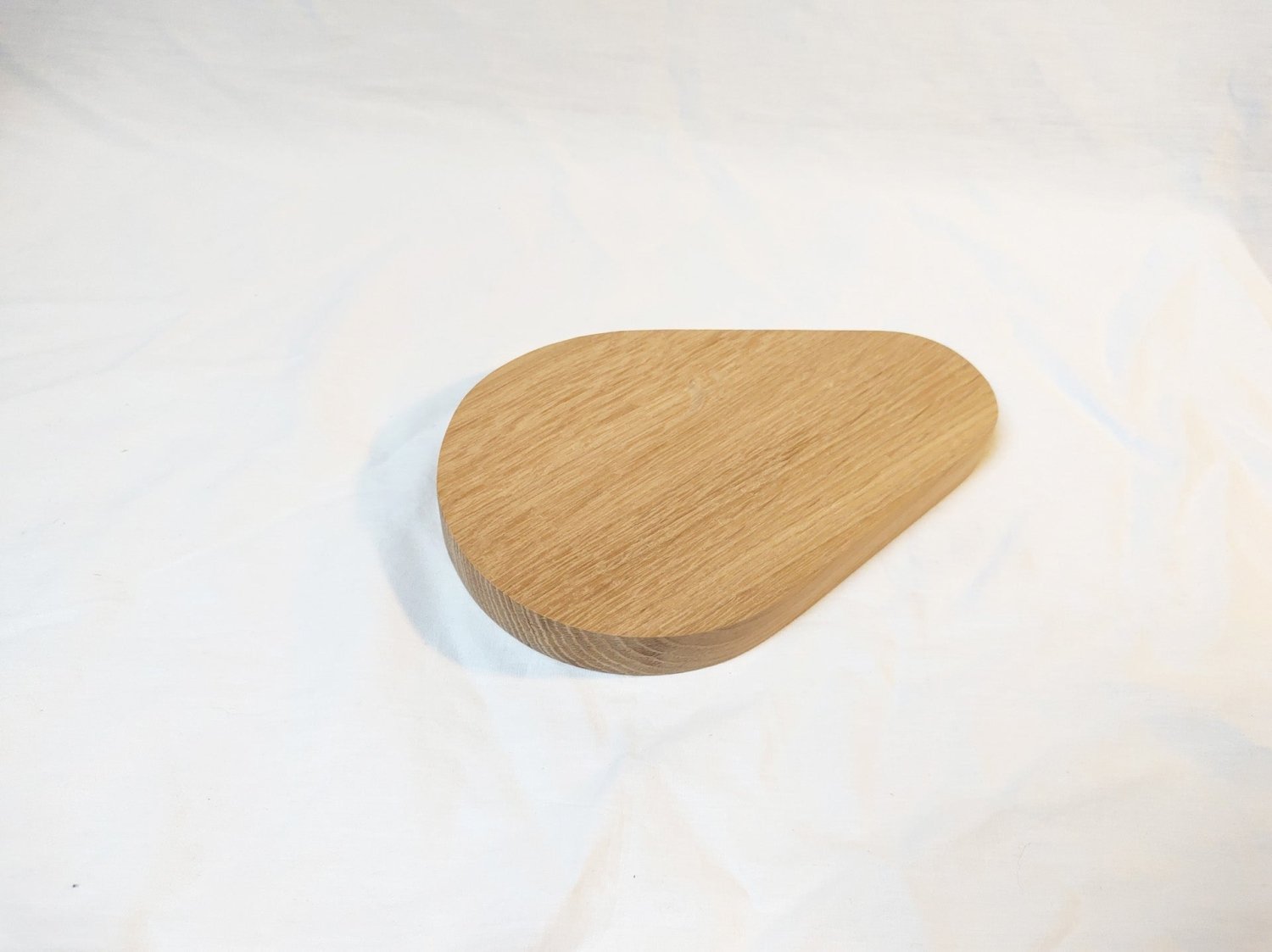 Wooden pear-shaped cutting board with rounded curves and smooth top