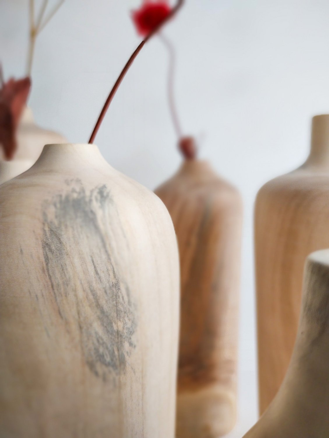 Maple wood mini vases close-up, gray-grain vase beside tan vases