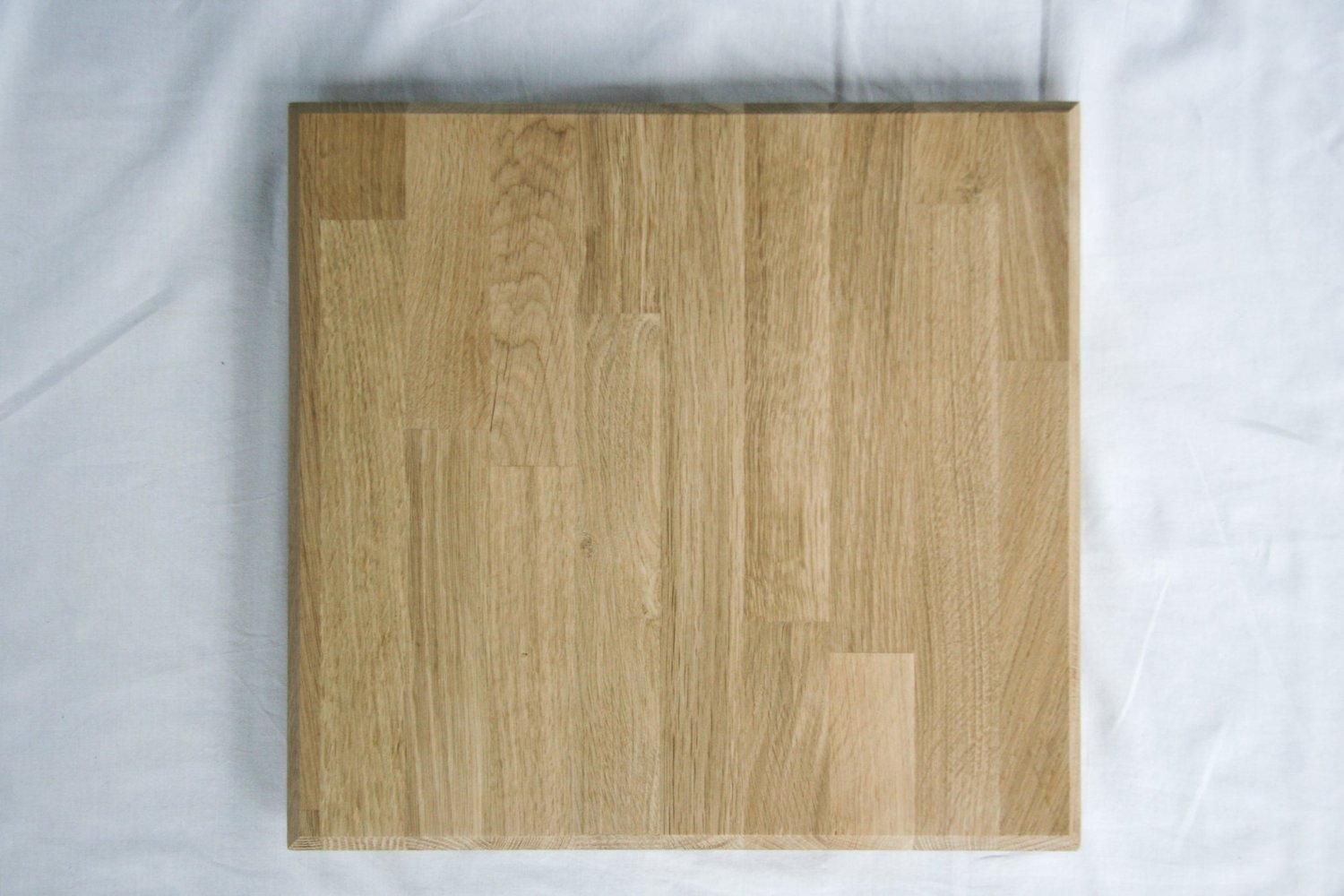 Rectangular wooden chopping board with a smooth, light wood grain surface