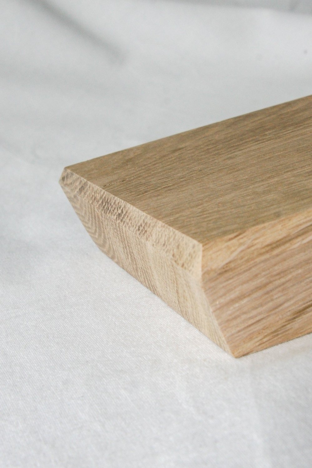 Close-up of rectangular wooden serving board edge with carved texture