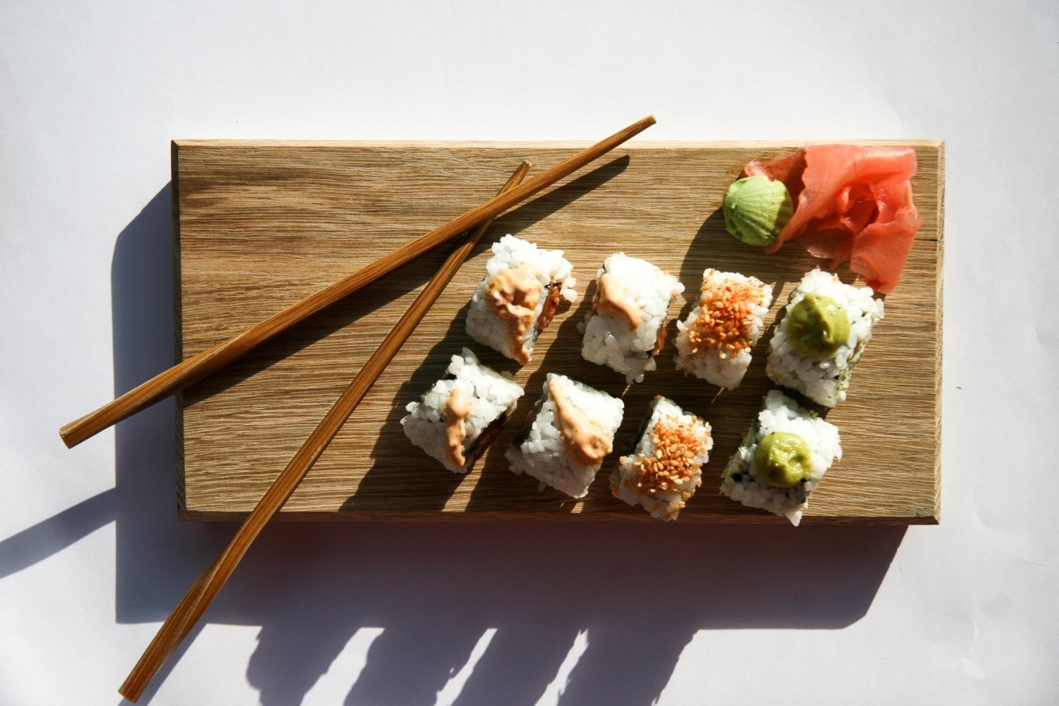Wooden serving board with chopsticks and a platter of assorted sushi