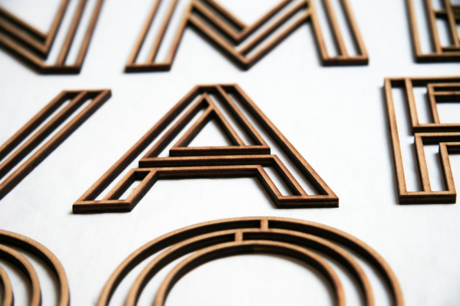 Wooden letter A with layered dark and light brown wood stripes