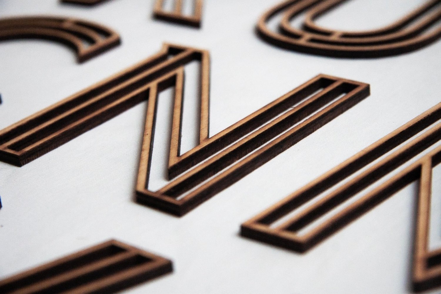 Wooden letter N with stacked dark and light brown wood inlays