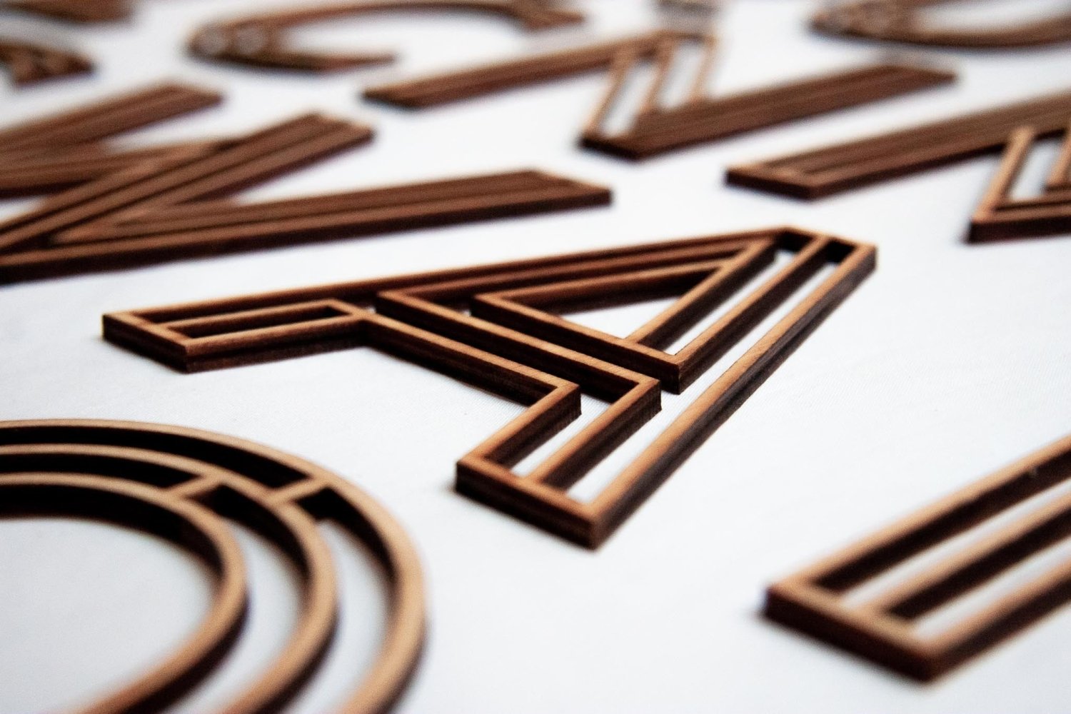 Wooden letter X with layered dark wood and light wood stripe details
